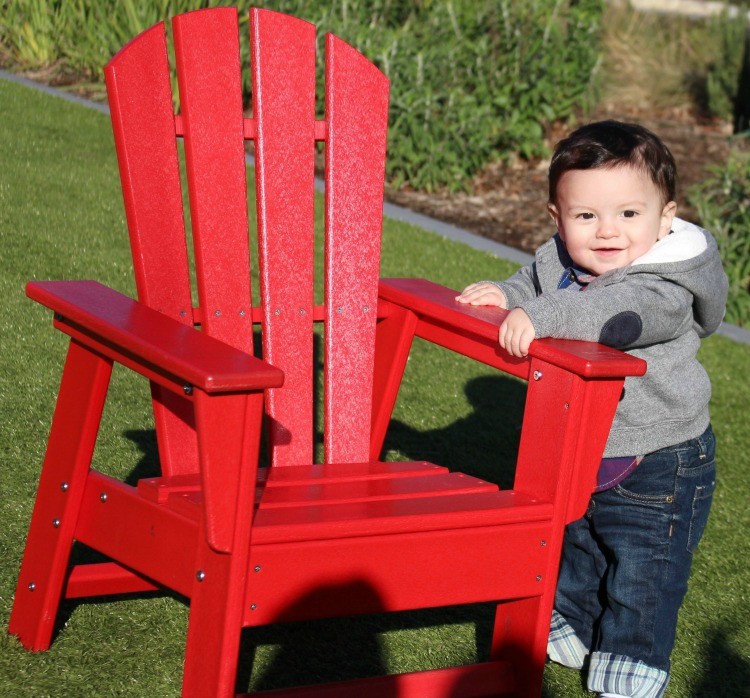 Manny standing with red chair