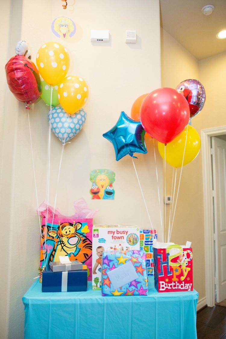 Celebrating turning one with balloons, Sesame Street, and a gift table