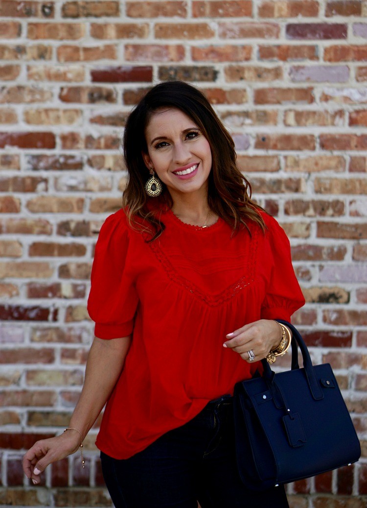 Statement earrings, red top, and dark skinny jeans