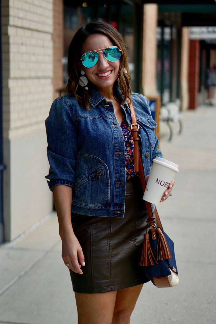 Aviators, jean jacket, floral top, leather miniskirt, and white earrings